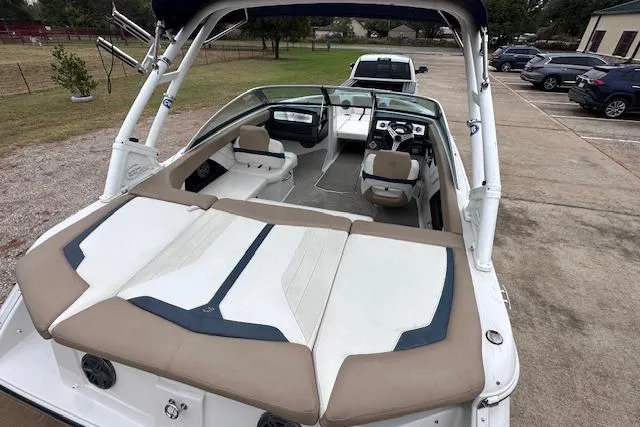 Slide: The Image of 2013 Four Winns H210SS boat with spacious seating and sleek design, parked outdoors. - 10