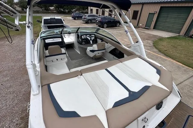 Slide: The Image of 2013 Four Winns H210SS boat interior with seating and dashboard, parked outdoors. - 11
