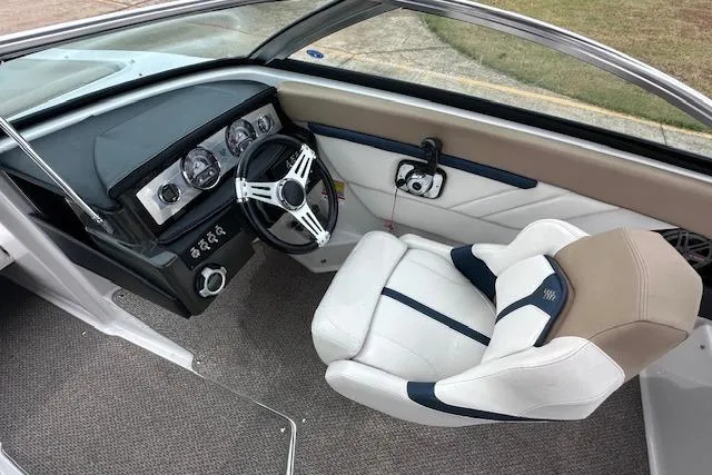 Slide: The Image of 2013 Four Winns H210SS boat interior with steering wheel and captain's seat. - 12