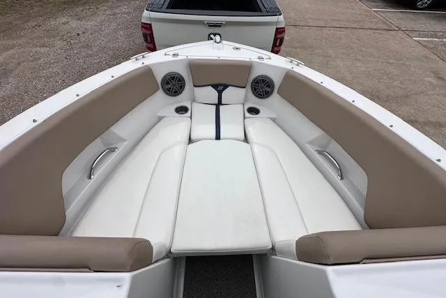 Slide: The Image of 2013 Four Winns H210SS boat interior with beige and white seating, parked on a trailer. - 15
