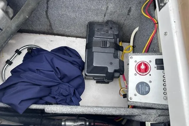 Slide: The Image of 2013 Four Winns H210SS boat interior with battery box, wiring, and control panel. - 20