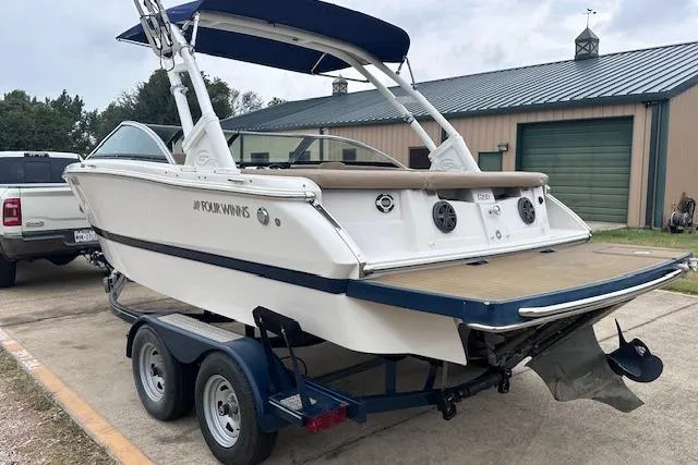 Slide: The Image of 2013 Four Winns H210SS boat on trailer, parked outdoors near a garage. - 3