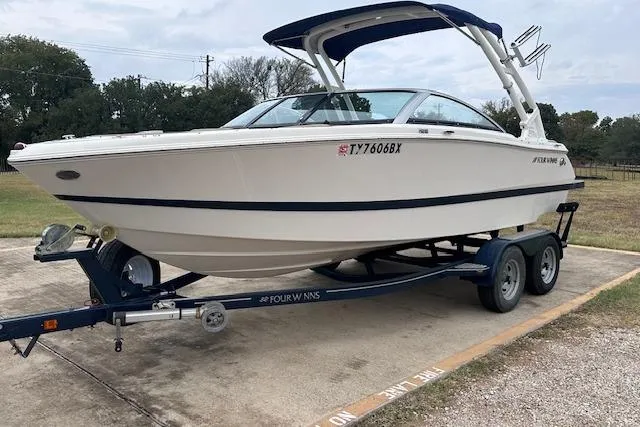 Slide: The Image of 2013 Four Winns H210SS boat on trailer, parked outdoors. - 5