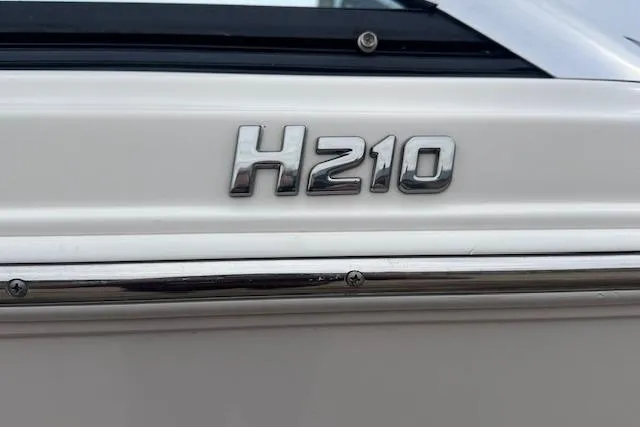 Slide: The Image of 2013 Four Winns H210SS boat emblem on white surface. - 6