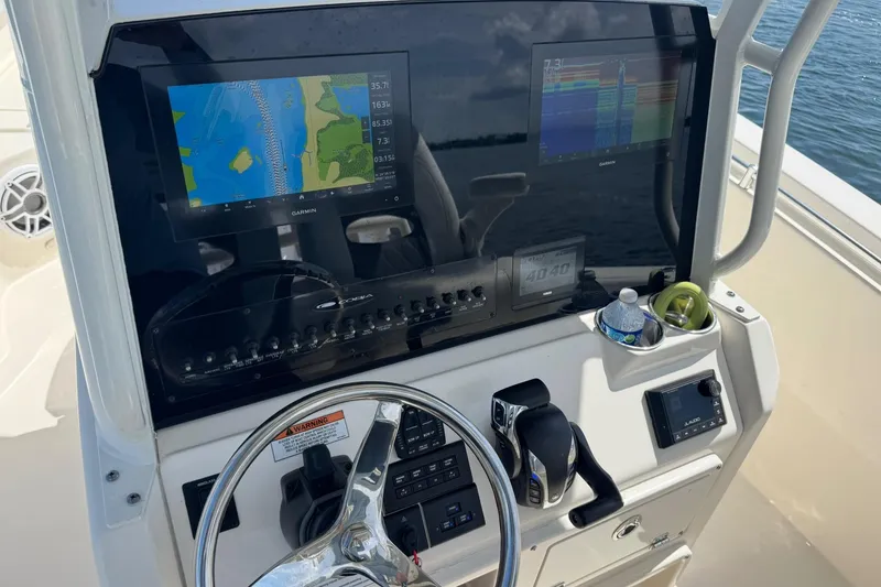 Slide: The Image of 2023 Cobia 280 Center Console dashboard with Garmin displays and steering wheel. - 10