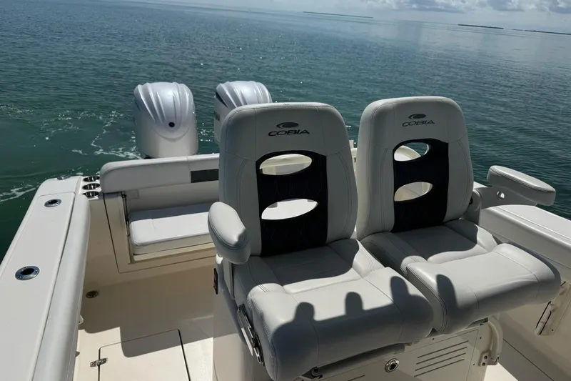 Slide: The Image of 2023 Cobia 280 Center Console boat with dual engines and comfortable seating on open water. - 13
