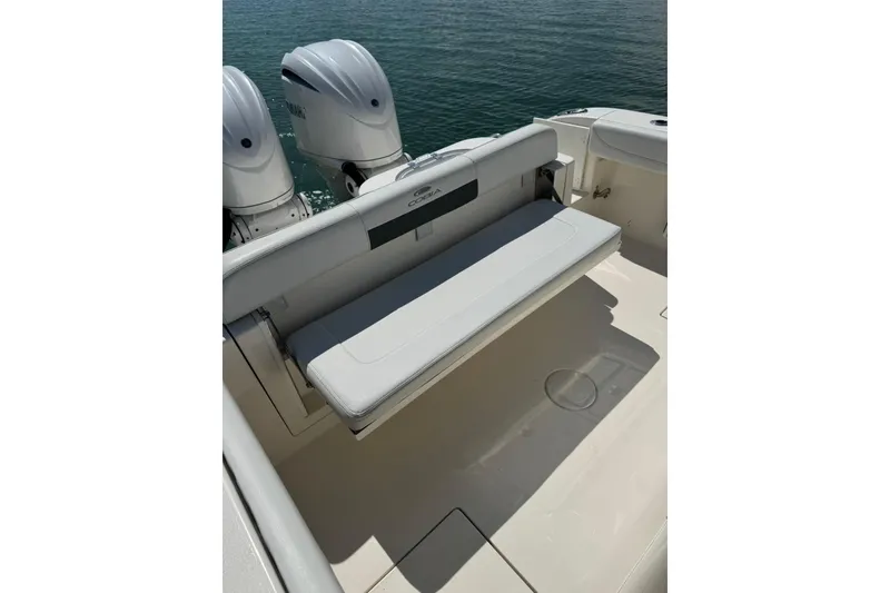 Slide: The Image of 2023 Cobia 280 Center Console boat with dual outboard engines and foldable rear seat. - 14