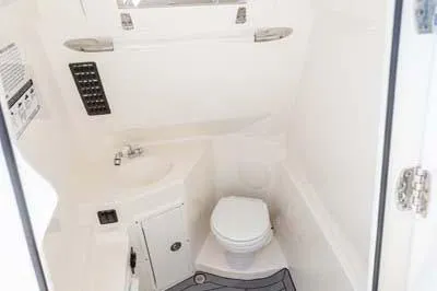 Slide: The Image of Manufacturer Provided Image: 2023 Cobia 280 Center Console boat interior bathroom with sink and toilet. - 16