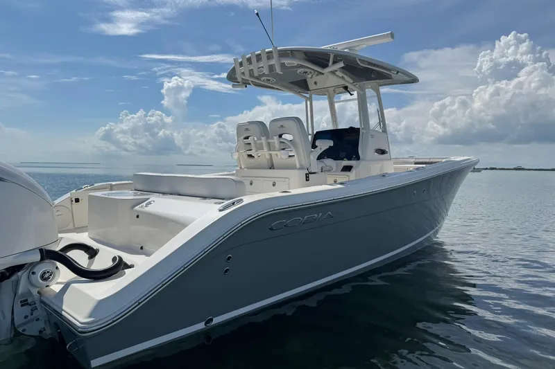 Slide: The Image of 2023 Cobia 280 Center Console boat on calm water under a cloudy sky. - 3