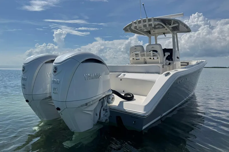 Slide: The Image of 2023 Cobia 280 Center Console boat with twin Yamaha engines on calm water. - 4
