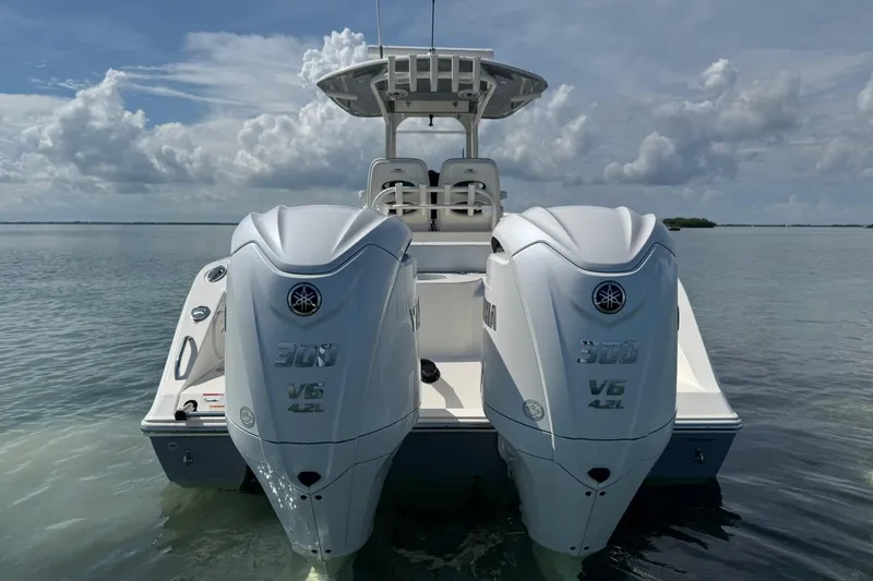 Slide: The Image of 2023 Cobia 280 Center Console boat with twin Yamaha 300 V6 engines on calm water. - 5