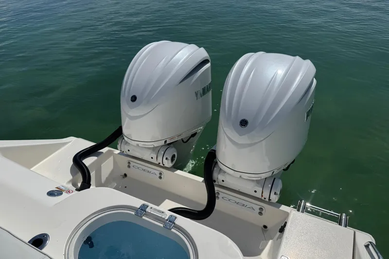 Slide: The Image of 2023 Cobia 280 Center Console with dual Yamaha outboard motors on calm water. - 8