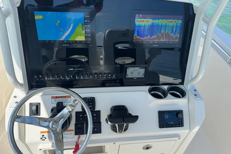 Slide: The Image of 2023 Cobia 280 Center Console dashboard with Garmin displays and steering wheel. - 9