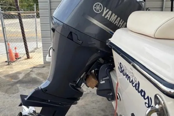 Slide: The Image of 2015 Grady-White Adventure 208 boat with Yamaha outboard motor, parked near a fence. - 4