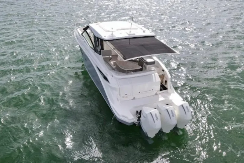 Slide: The Image of 2022 Sea Ray Sundancer 320 Outboard cruising on open water, showcasing triple engines. - 10
