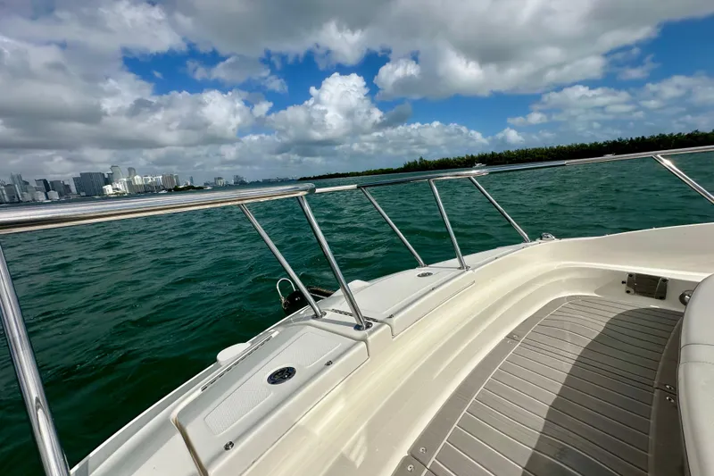 Slide: The Image of 2022 Sea Ray Sundancer 320 Outboard cruising on a sunny day with city skyline view. - 15