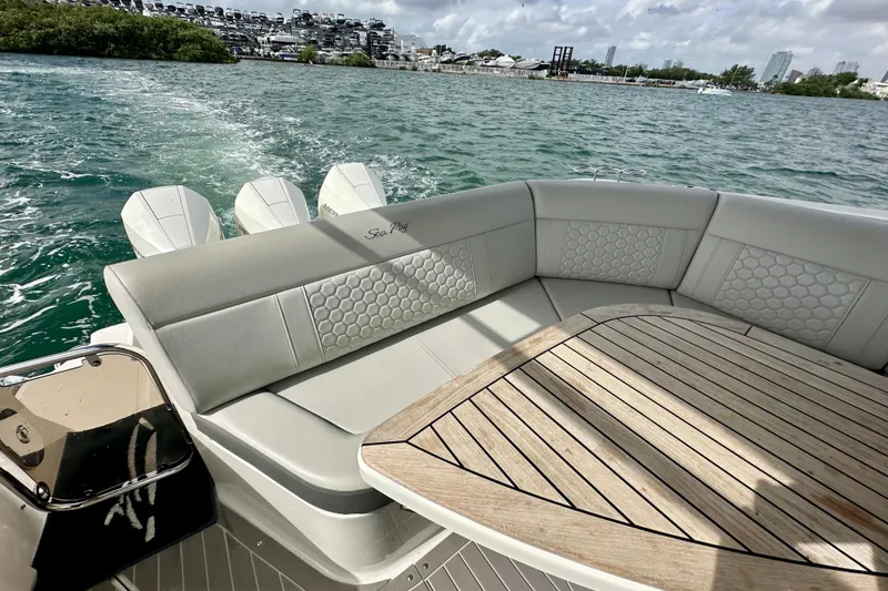 Slide: The Image of 2022 Sea Ray Sundancer 320 Outboard with elegant seating and wooden table on open water. - 30