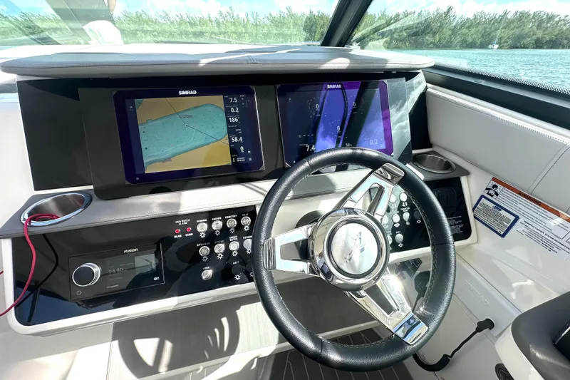 Slide: The Image of 2022 Sea Ray Sundancer 320 Outboard helm with navigation screens and controls. - 35