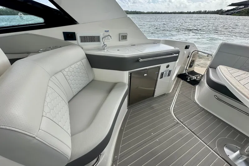 Slide: The Image of 2022 Sea Ray Sundancer 320 Outboard interior with seating and kitchenette, overlooking water. - 42