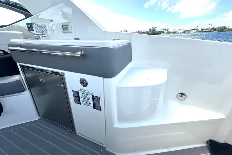 Slide: The Image of 2022 Sea Ray Sundancer 320 Outboard interior with sleek kitchenette and stainless steel accents. - 43