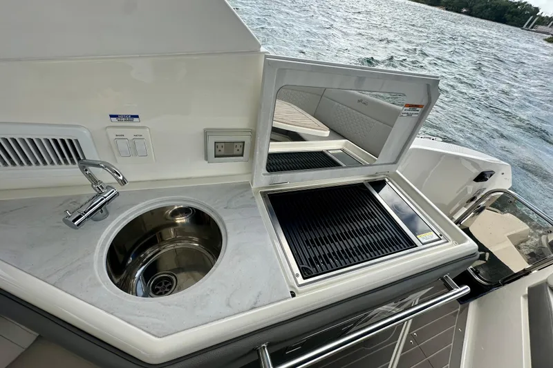 Slide: The Image of Outdoor kitchen on 2022 Sea Ray Sundancer 320 Outboard with sink and grill by the water. - 44