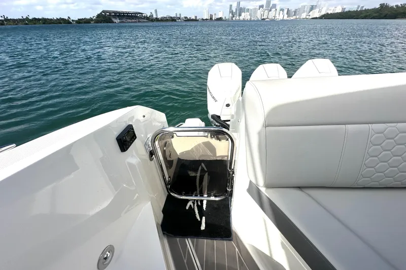 Slide: The Image of 2022 Sea Ray Sundancer 320 Outboard, rear view with seating and water backdrop. - 51