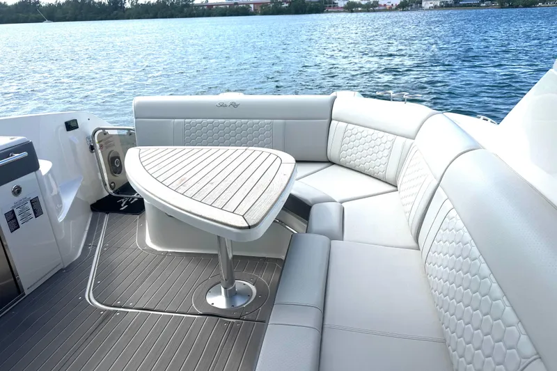 Slide: The Image of 2022 Sea Ray Sundancer 320 Outboard boat interior with elegant seating and table by the water. - 57