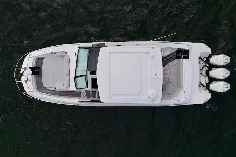 Slide: The Image of Overhead view of 2022 Sea Ray Sundancer 320 Outboard on water, showcasing sleek design and triple engines. - 6