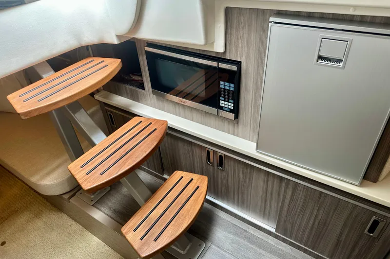 Slide: The Image of Interior of 2022 Sea Ray Sundancer 320 Outboard with wooden steps, microwave, and compact fridge. - 62