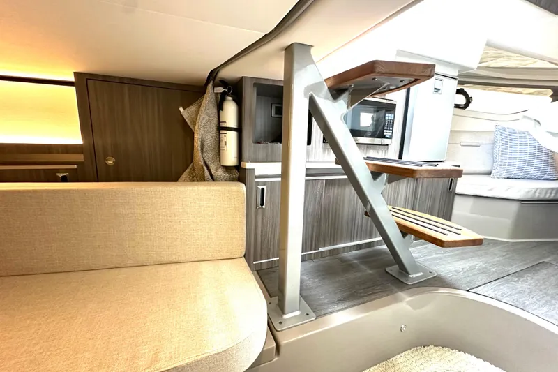 Slide: The Image of Interior of 2022 Sea Ray Sundancer 320 Outboard, featuring modern seating and wooden steps. - 64