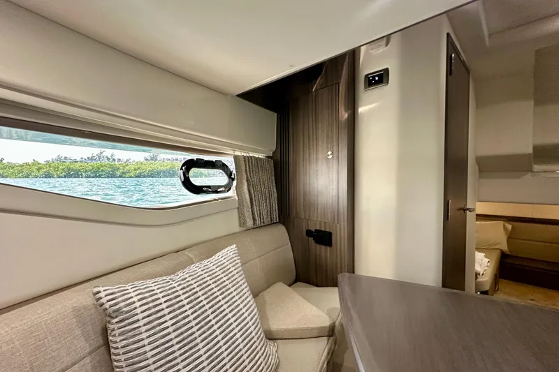 Slide: The Image of Interior of 2022 Sea Ray Sundancer 320 Outboard, featuring elegant seating and scenic window view. - 69