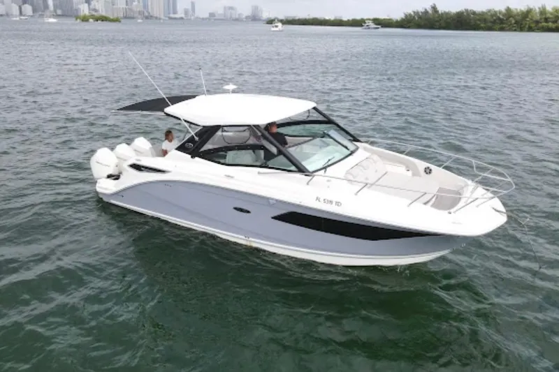 Slide: The Image of 2022 Sea Ray Sundancer 320 Outboard cruising on open water near city skyline. - 7