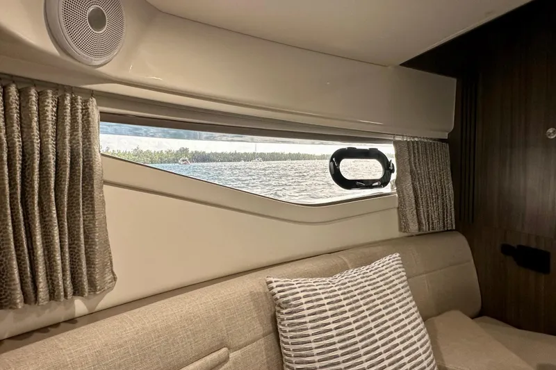 Slide: The Image of Interior view of 2022 Sea Ray Sundancer 320 Outboard, featuring a window with curtains and a speaker. - 70