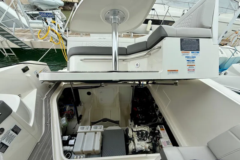 Slide: The Image of 2022 Sea Ray Sundancer 320 Outboard engine compartment with open hatch, docked at marina. - 77
