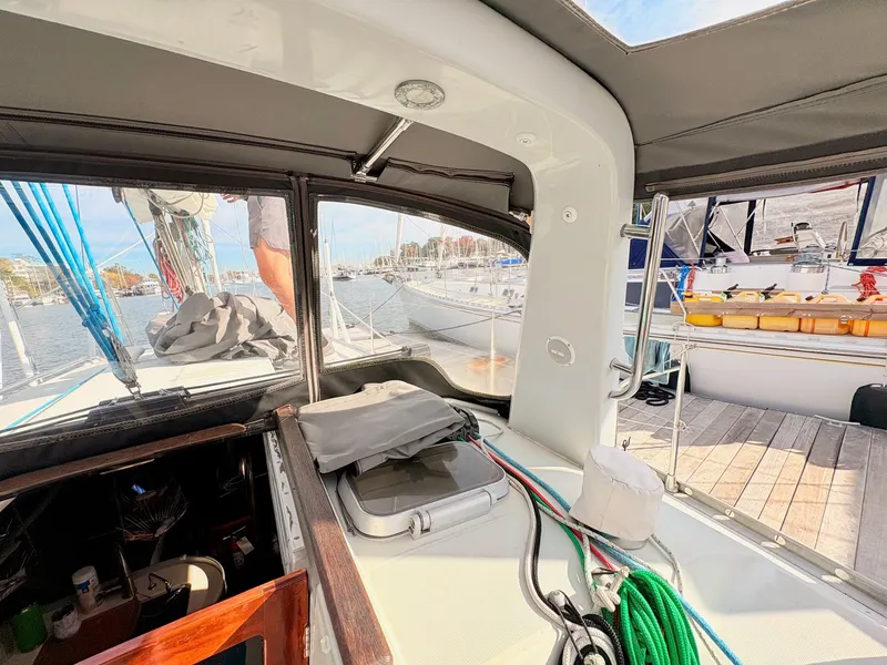 Slide: The Image of Cockpit view of a 1990 Beneteau 38 sailboat, docked in a serene marina. - 14