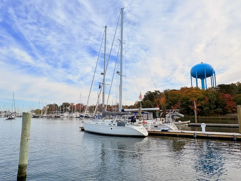 Slide: The Image of Sailboat docked at marina with blue water tower, Beneteau 38, 1990 model. - 2
