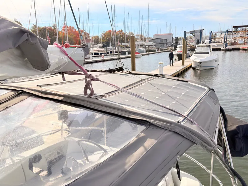 Slide: The Image of Beneteau 38 sailboat from 1990 docked at a marina, surrounded by other boats. - 22