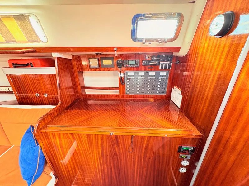 Slide: The Image of Interior of a 1990 Beneteau 38 sailboat with wood paneling and orange seating. - 26