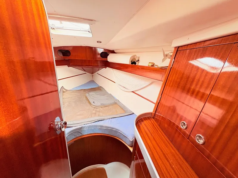 Slide: The Image of Interior of 1990 Beneteau 38 sailboat with wood paneling and cozy seating area. - 31