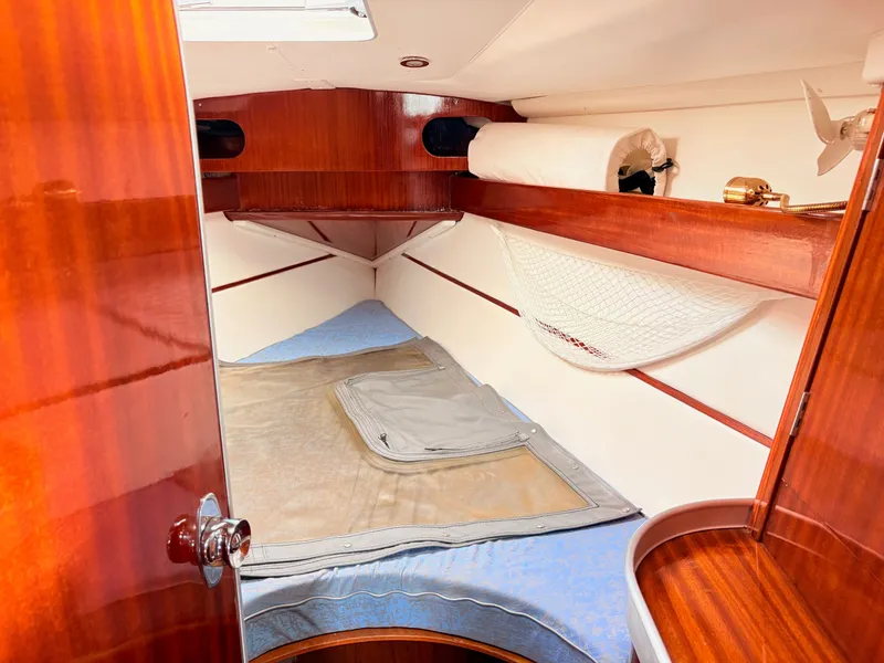 Slide: The Image of Cozy cabin interior of 1990 Beneteau 38 sailboat with wooden finish and bedding. - 33