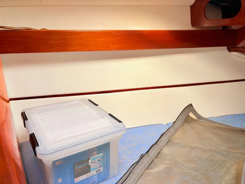 Slide: The Image of Interior cabin of a 1990 Beneteau 38 sailboat with wooden finishes and storage. - 34
