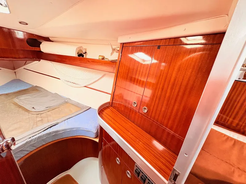 Slide: The Image of Cozy cabin interior of 1990 Beneteau 38 sailboat with wooden finish and bedding. - 35