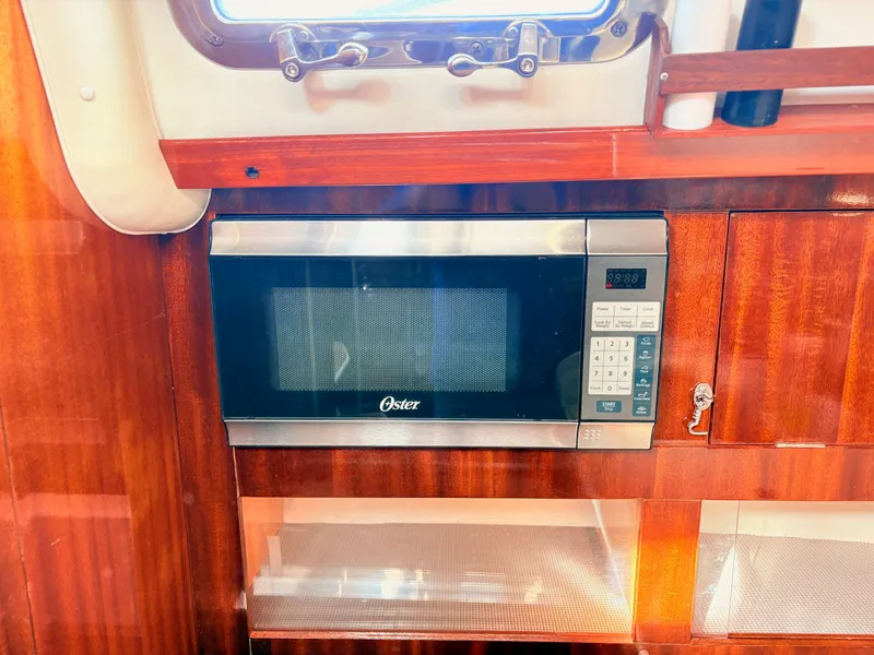 Slide: The Image of Interior of a 1990 Beneteau 38 yacht kitchen with wood finish and modern amenities. - 41