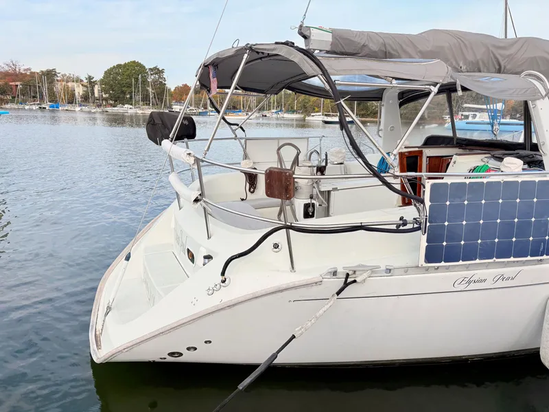 Slide: The Image of 1990 Beneteau 38 sailboat docked, featuring solar panels and covered cockpit. - 5