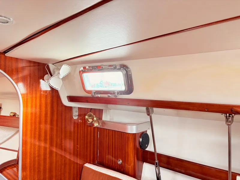 Slide: The Image of Interior of 1990 Beneteau 38 yacht with wooden cabinetry and porthole window. - 51