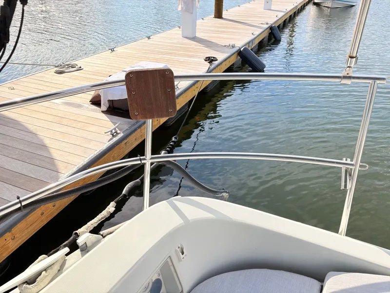 Slide: The Image of Steering wheel of a 1990 Beneteau 38 sailboat, docked by the water. - 9