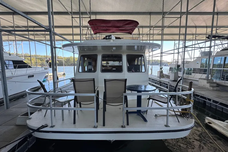 Slide: The Image of 1993 Gibson 44 Cabin Yacht docked, featuring outdoor seating and covered marina. - 2