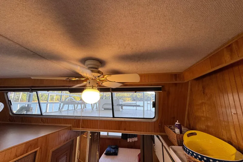 Slide: The Image of Interior of 1993 Gibson 44 Cabin Yacht with ceiling fan and wooden paneling. - 20