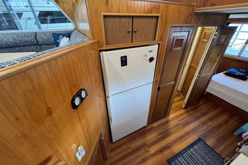 Slide: The Image of Interior of 1993 Gibson 44 Cabin Yacht with wood paneling and refrigerator. - 21