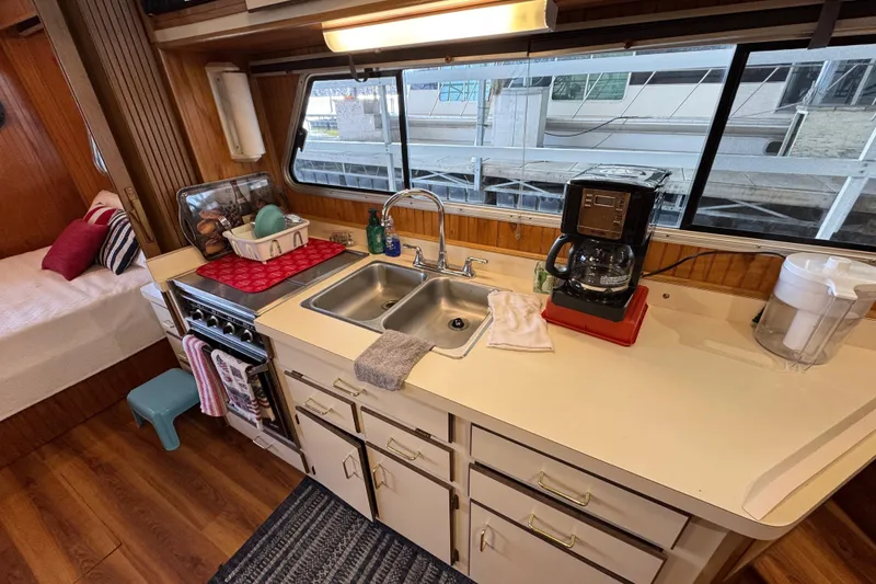 Slide: The Image of 1993 Gibson 44 Cabin Yacht kitchen with sink, coffee maker, and window view. - 22